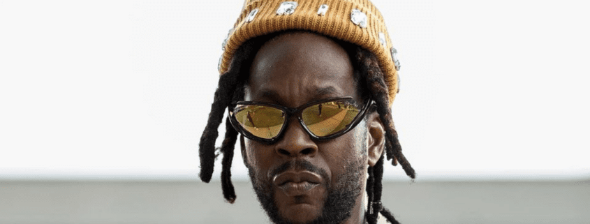 Man wearing yellow beanie and sunglasses.